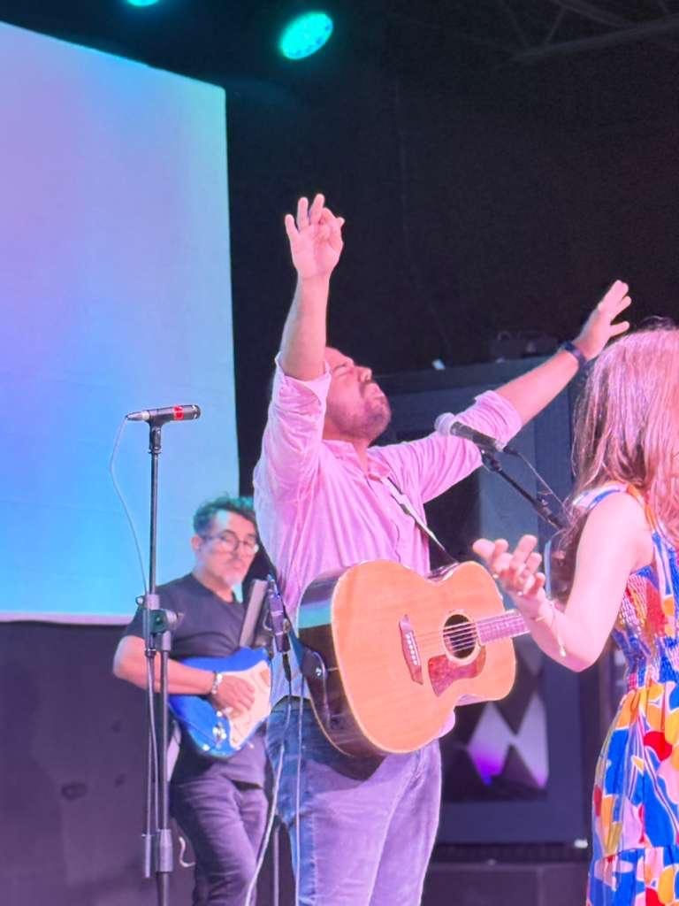 Congregación de Iglesia Vida Plena en adoración con las manos levantadas
